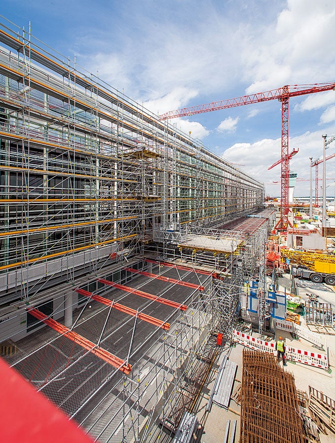 Die PERI UP Gerüstkonstruktion schirmt Baustellen- und Flughafenbetrieb zuverlässig voneinander ab. Gleichzeitig dient sie für die Fassadenbauer als Arbeitsgerüst. Treppenzugänge und weitgespannte Überbrückungen komplettieren die Gerüstlösung der Weißenhorner Experten.