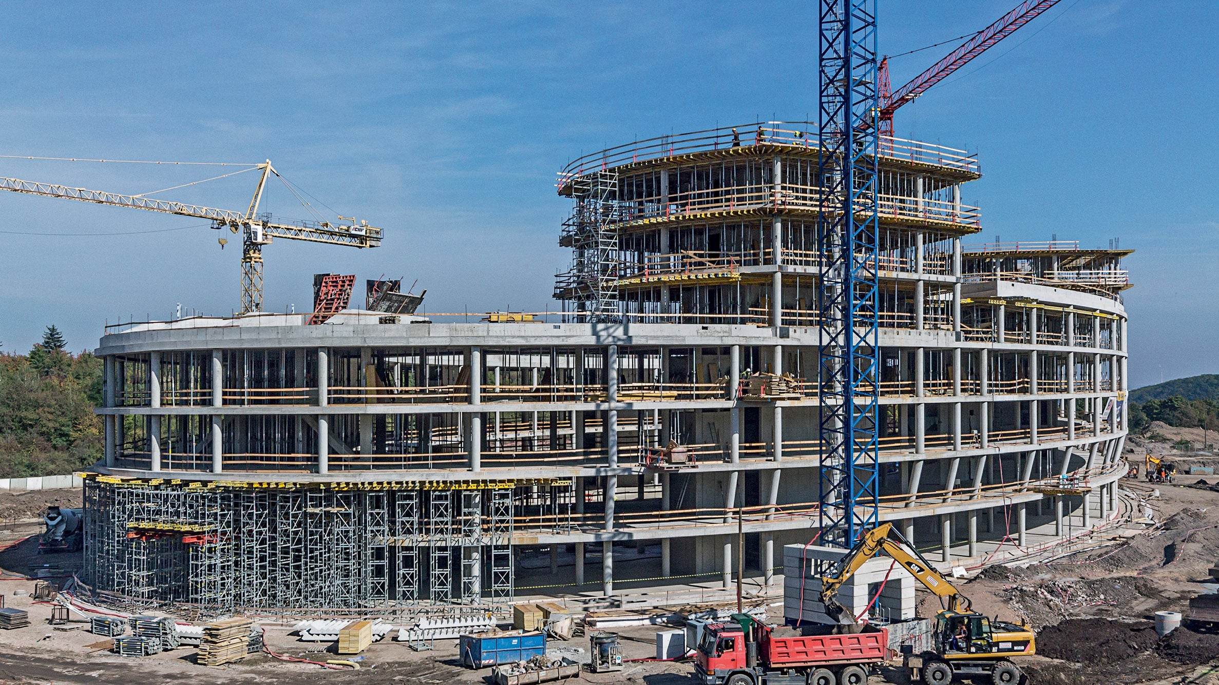 Budova se 3 - 4 nadzemními podlažími a dvěma čtyřpodlažními elipsovitými nástavbami. 