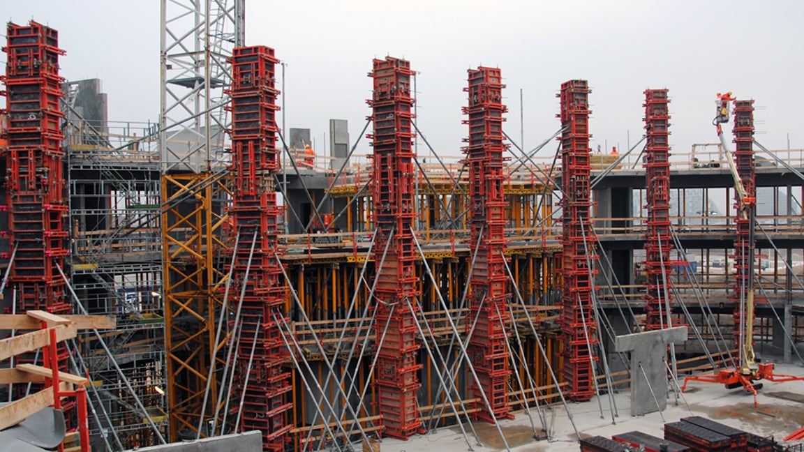 14 m høje TRIO søjler med ens finér aftryk.<br/>I baggrunden ses dækstøbningerne hvor der benyttes MULTIFLEX til at føre lasterne til terrændæk.<br/>