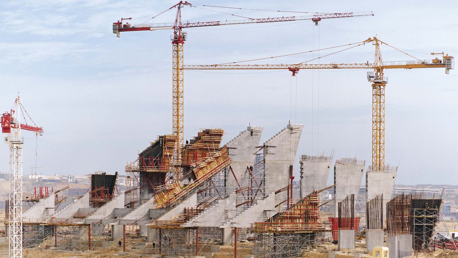 斜めの連結梁につながっている、スタンドを支える最高30 m の大規模な建築物は、内側で三角形の壁、外側で台形の壁から構成されています。