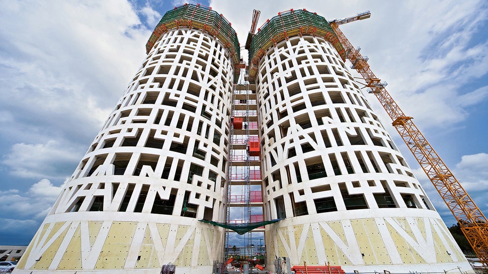 Em toda a altura, letras superdimensionadas na fachada de concreto simbolizam a inscrição "Non plus ultra".