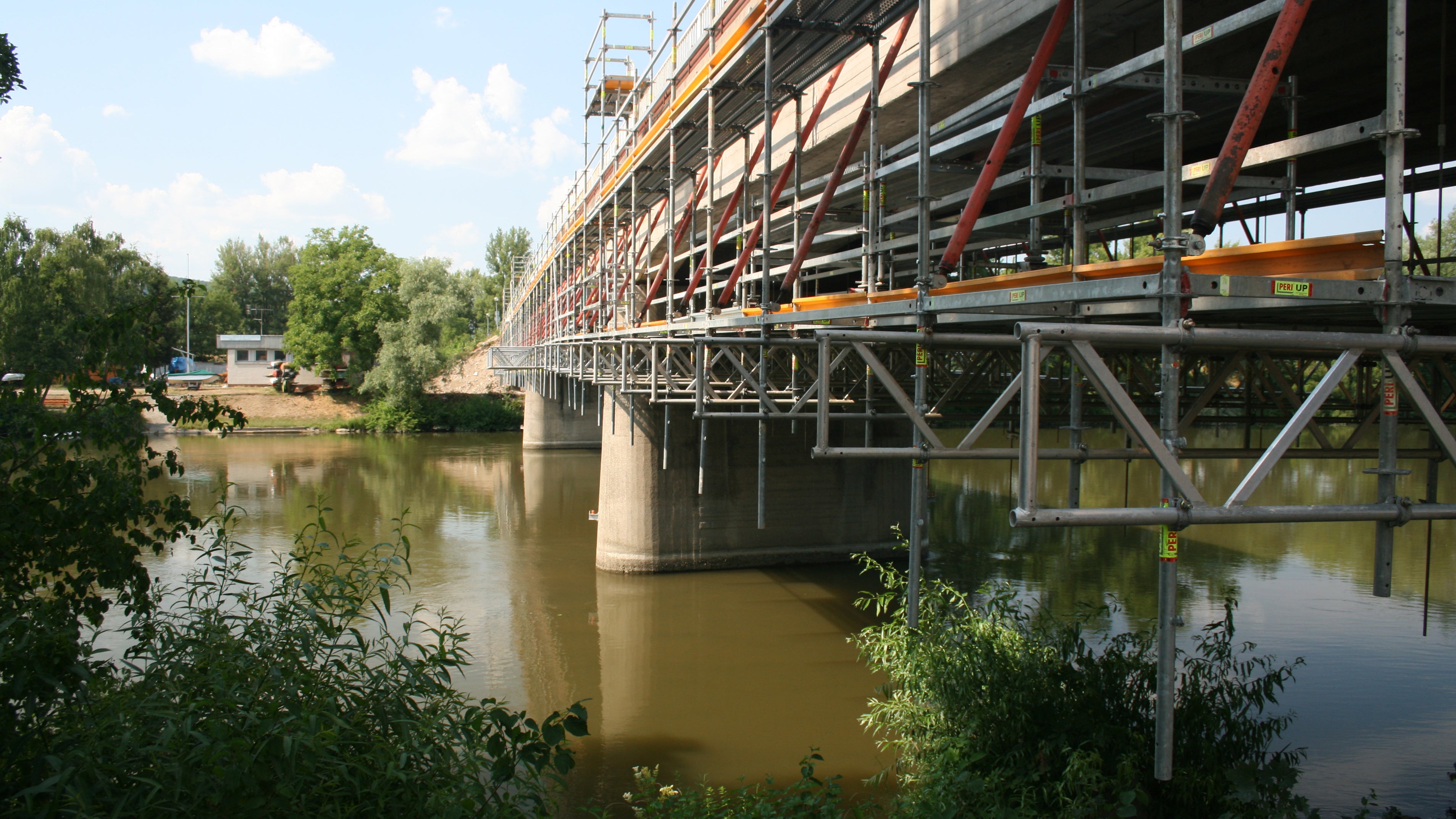Podmienkou rekonštrukcia starého mosta v Trenčíne na Ostrov bolo aby ostal v neustálej prevádzke, preto PERI navrhla v mieste vodnej hladiny Váhu zavesenú pracovnú podlahu vo výške cca. 2,00 m pod spodnou hranou mostnej konštrukcie.
