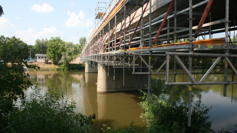 Podmienkou rekonštrukcia starého mosta v Trenčíne na Ostrov bolo aby ostal v neustálej prevádzke, preto PERI navrhla v mieste vodnej hladiny Váhu zavesenú pracovnú podlahu vo výške cca. 2,00 m pod spodnou hranou mostnej konštrukcie.