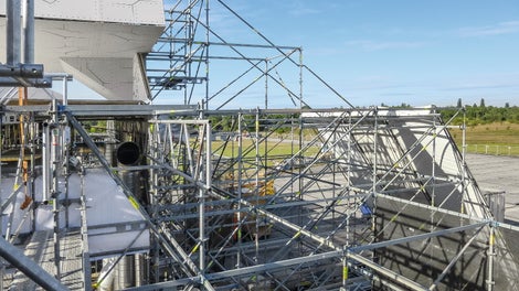 Částečné zakrytí vrchní části konstrukce a postranní věže pomocí vysunutí s diagonál a příhradových vazníků.