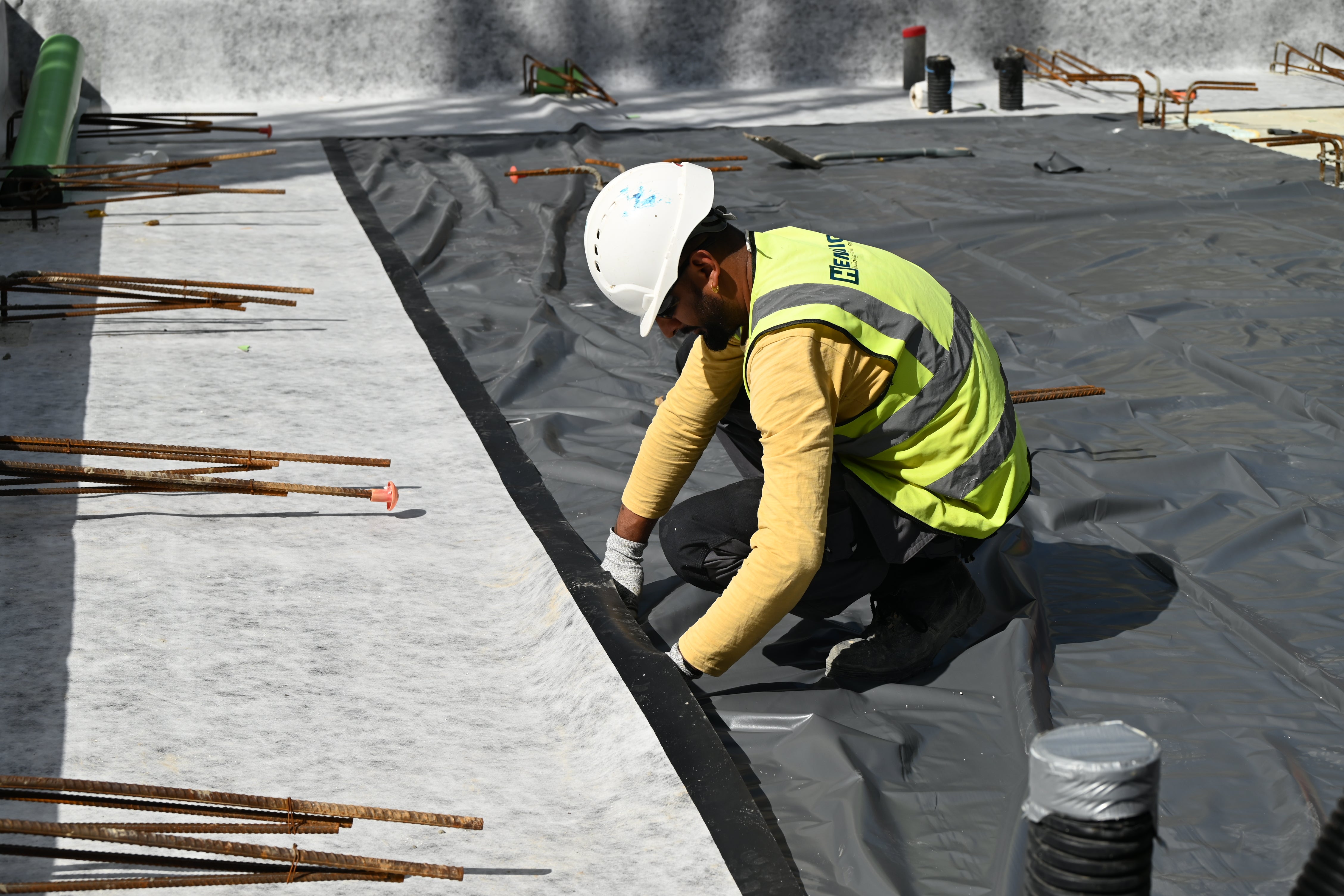 Specialist team installing a structural waterproofing system on site, demonstrating early-stage application to improve efficiency and reduce the risk of delays.