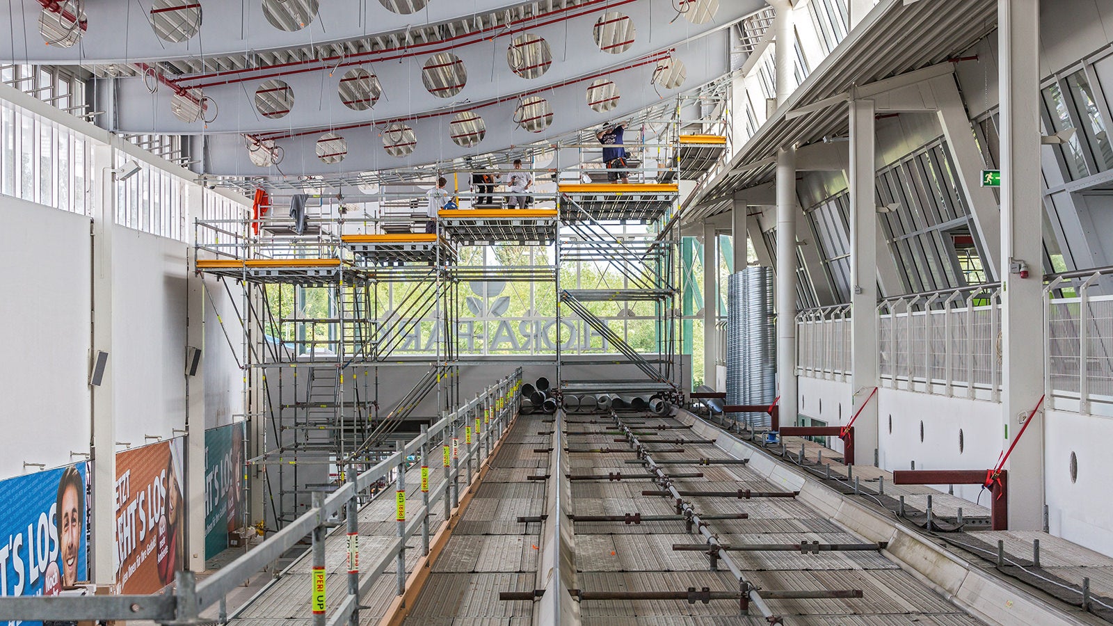 Auf dem Schutztunnel montierte Alu-Fahrschienen des LGS Systems ermöglichen die Verfahrbarkeit der abgetreppten Arbeitsbühne zur Dachbinderbearbeitung.