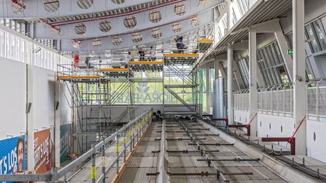 Auf dem Schutztunnel montierte Alu-Fahrschienen des LGS Systems ermöglichen die Verfahrbarkeit der abgetreppten Arbeitsbühne zur Dachbinderbearbeitung.