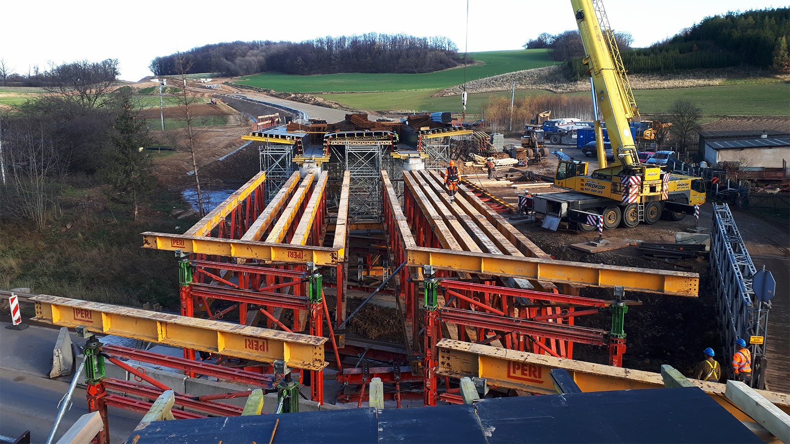 Skomplikowaniem tego zadania było usytuowanie dwóch przeszkód obok siebie w tym jednej o zmieniającej się rozpiętości dochodzącej do 22 m. Inżynierowie PERI wraz z Kadrą budowy przygotowali rozwiązanie gwarantujące osiągnięcie równomiernych ugięć deskowania i to wszystko przy 1-dniowym montażu kratownic i „bramki” nad drogą.