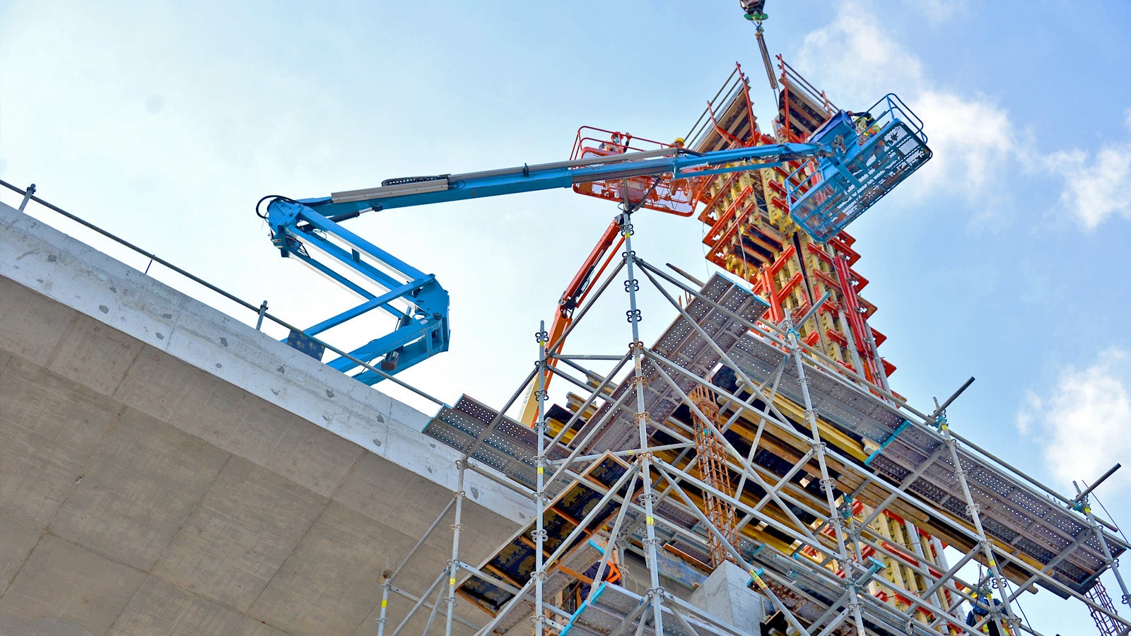 Construction crew on cranes working on the installation of VARIO GT 24 Column Formwork