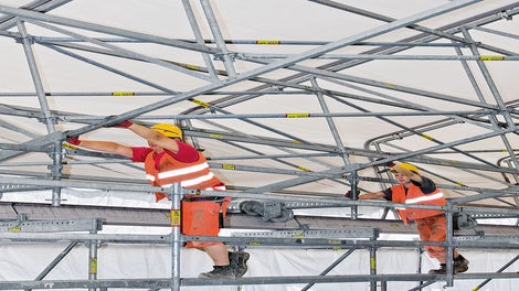 The roof elements can be moved in the longitudinal direction by means of wheels so that, for example, materials can be lifted in by crane.