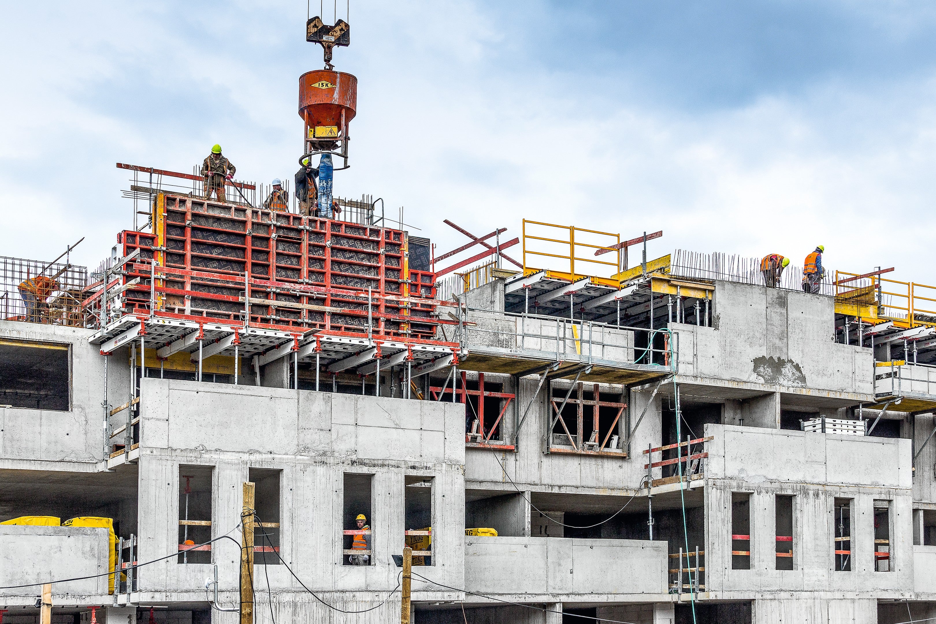 Pri debnení stien systémom TRIO bola bezpečnosť zaistená FB sklápacími lávkami a horizontálne zábradím SKYDECK.
