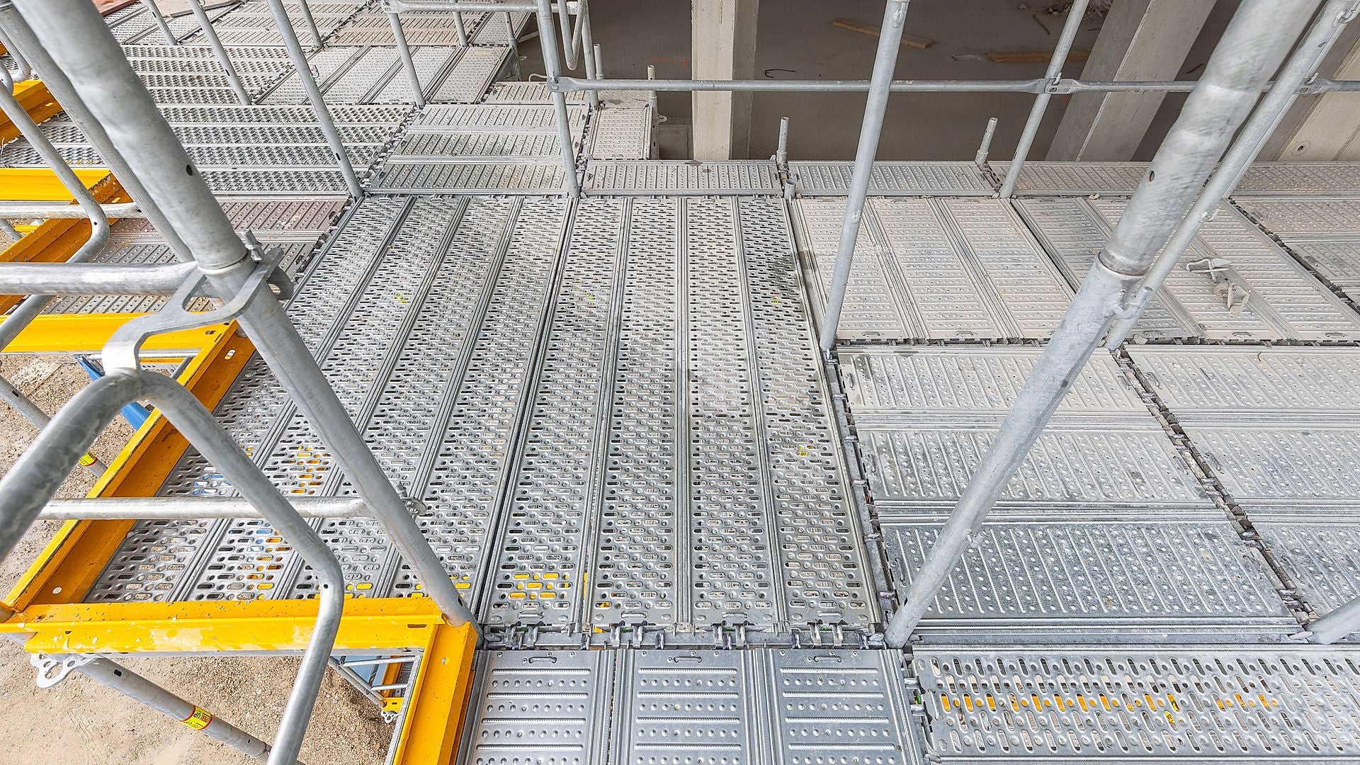 Rutschfeste Stahlbeläge sowie ebene, versatzfreie Belagsflächen sorgen für sichere Begehbarkeit und erleichtern den Materialtransport am Rohbau. Das Plus für ständigen Umbau: PERI UP Beläge lassen sich herausnehmen und einzelne Felder können sicher geöffnet und geschlossen werden.