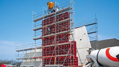 Auf der Landseite der Weißbeton, auf der Seeseite der metallische Körper – das ist die architektonische Idee, das Thema "Verbindung" auch mit der äußeren Gestaltung darzustellen. Auf halber Wandhöhe wird eine Betonierfuge eingeplant – ausgeführt mit einer Dreikantleiste.