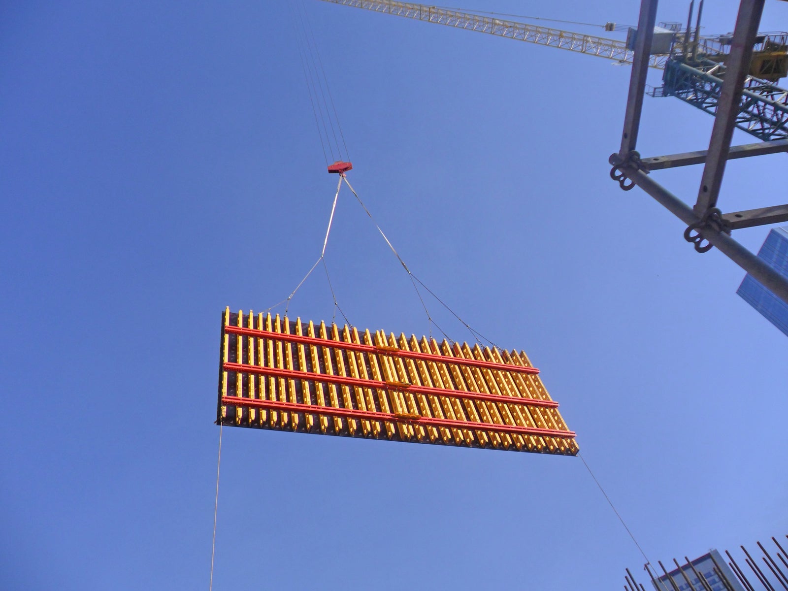 Painel de fôrma VARIO utilizada nos núcleos de concreto armado sendo içada pela grua, para locação definitiva sobre as plataforma do sistema auto trepante RCS. Uma vez locados os painéis sobre as plataformas, o sistema auto trepante é responsável pelo deslocamento vertical dos mesmos entre os níveis da construção<br/><br/>