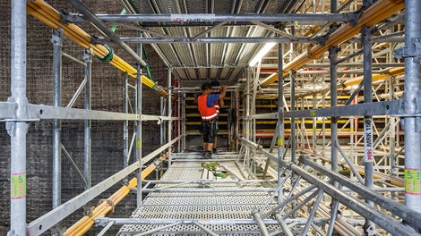 Horizontal eingesetzte, mit MRK Systemrahmen verbundene MULTIPROP Alu-Deckenstützen übernehmen die Aussteifung der Schalungselemente innerhalb der PERI UP Gerüstkonstruktion zur lagenweisen Betonage der Vorsatzschale.