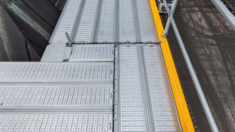 Selbst bei Außenecken in Kombination mit innenseitigen Konsolverbreiterungen konnte die oberste Gerüstlage komplett mit Systembelägen sicher ausgebildet werden.