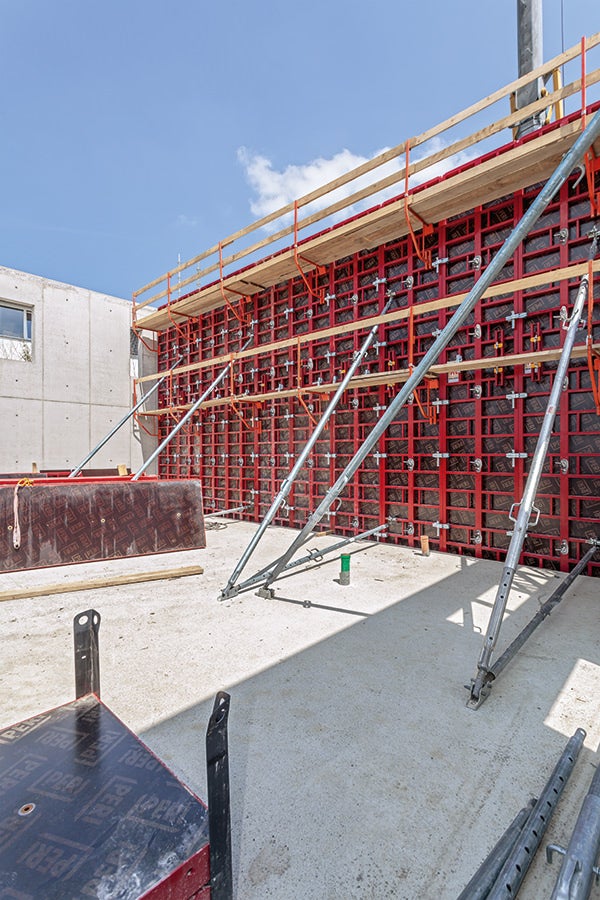 Aufgestockt eingesetzte MAXIMO Elemente MX 330x120 ergeben für die 6,60 m hohen Außenwände ein geordnetes Betonbild.