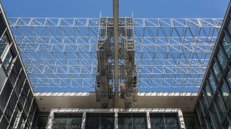 The suspended scaffold units are moved along the edges of the buildings on trolleys without a crane. After closing of the intermediate fields in longitudinal and transverse direction – including the lower deck level – the concrete truss is completely enclosed. <br/>