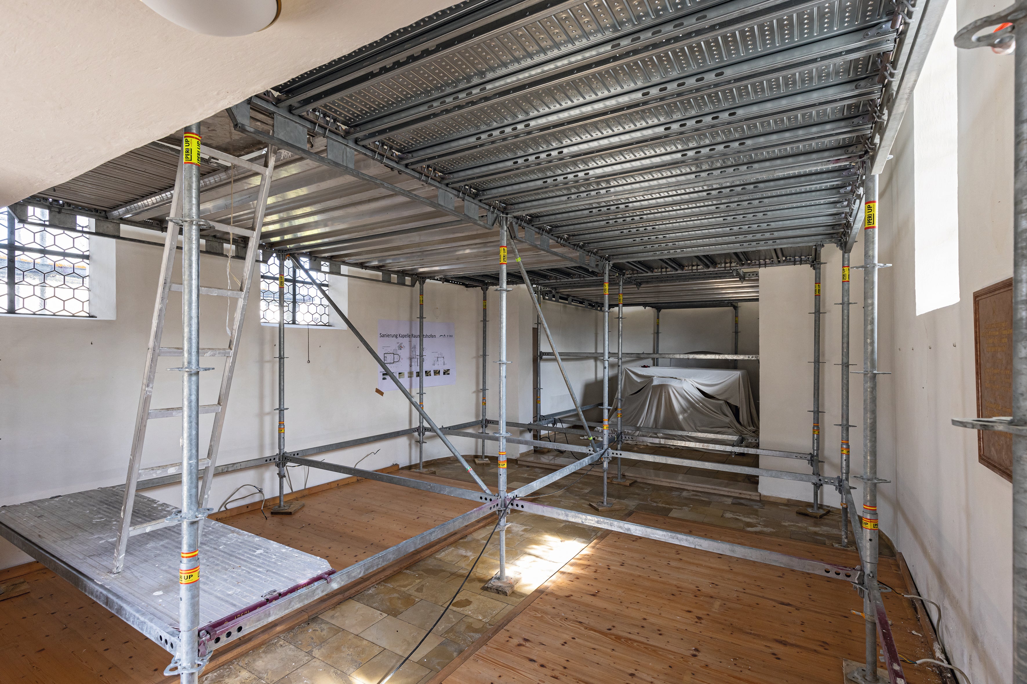 Im Innenraum schafft ein räumlich angepasstes PERI UP Gerüst eine sichere Arbeitsebene für die Arbeiten an der Deckenunterseite und an den Deckenmalereien.