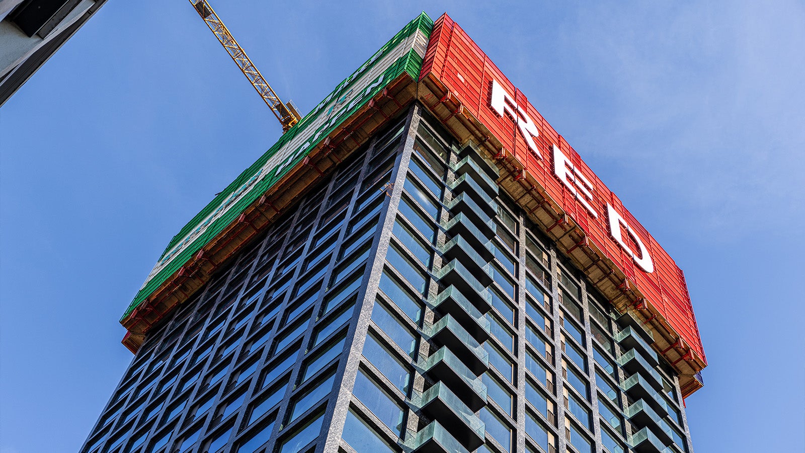 Het PERI RCS-P veiligheidsscherm rond de woontoren combineert ruw- en afbouw in één klimsysteem.