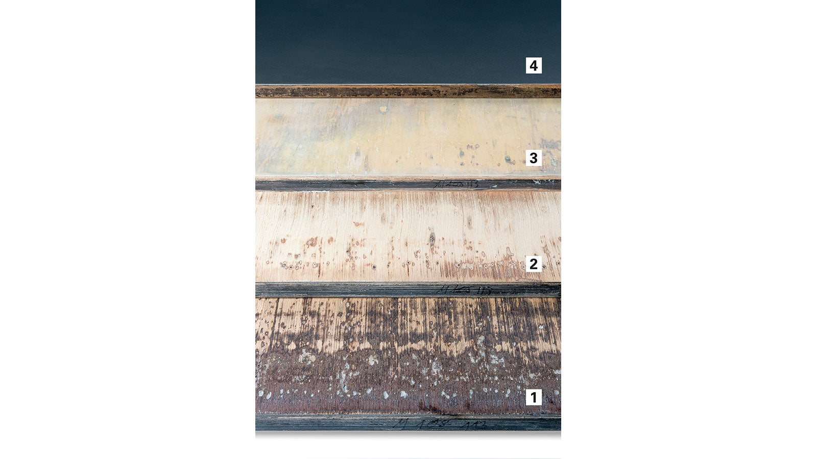 The various process steps during repair operations (from bottom to top):<br/>1. Coarsely-sanded surface<br/>2. Finely-sanded surface<br/>3. Result Renocare C<br/>4. Result Renocare Special with a new plastic laminate<br/>