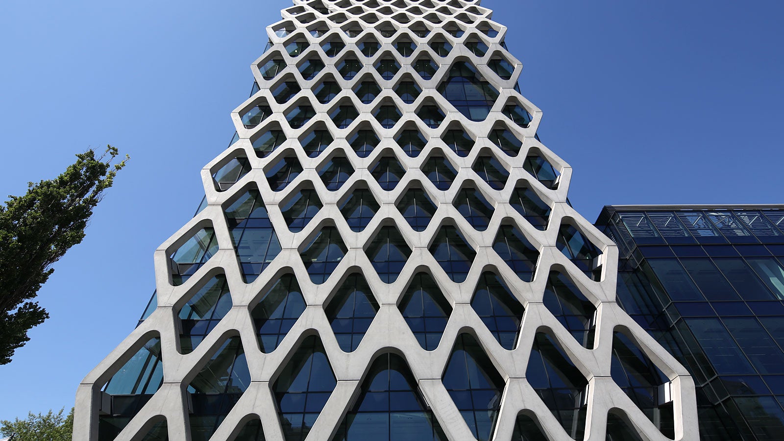 A filigree reinforced concrete net covering the glass facade of the Prosta Tower in Warsaw.