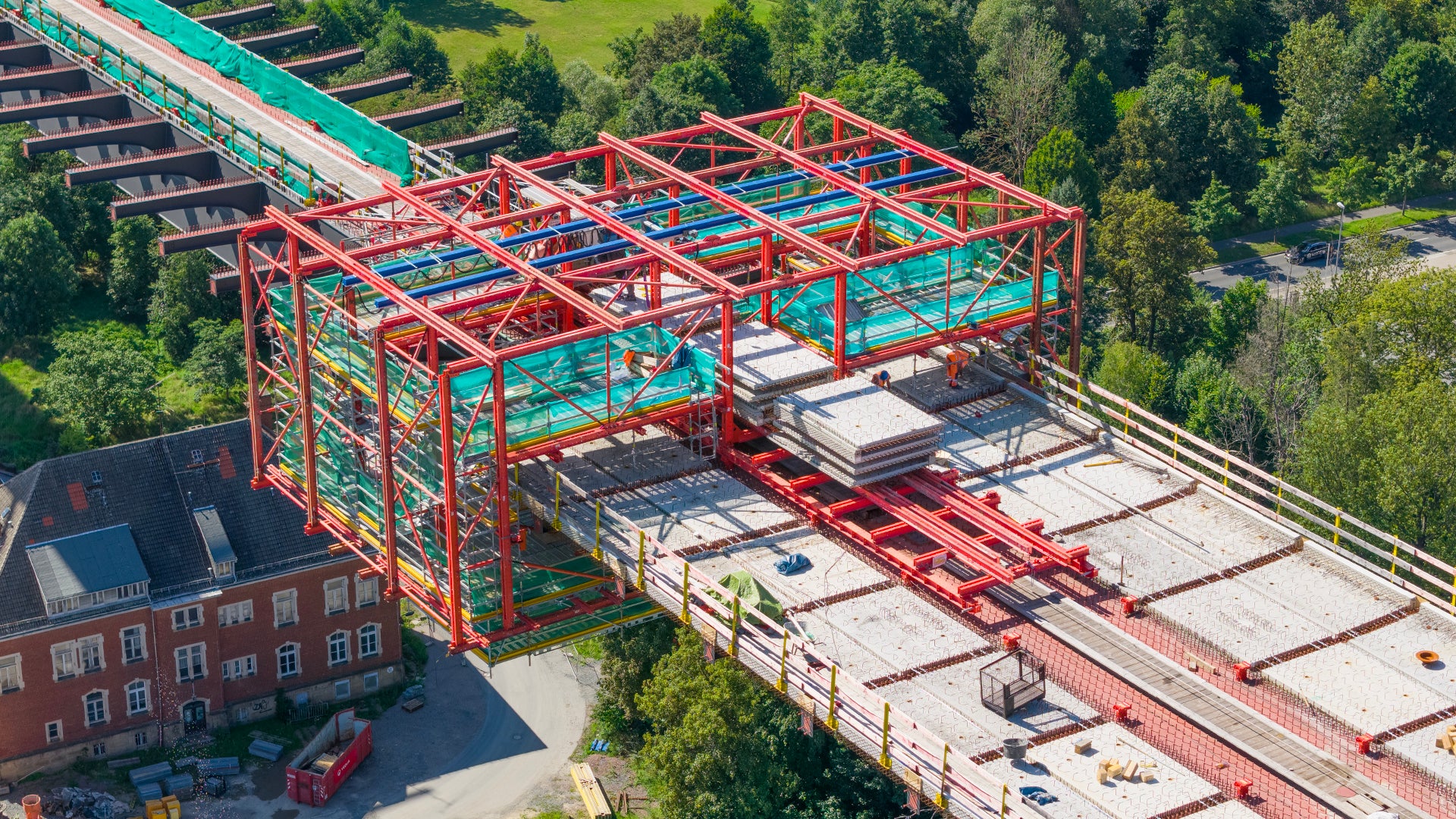 Die modulare Stahlverbundbauweise erfordert das Verlegen von Halbfertigteilen auf die Stahlquerträger in luftiger Höhe.<br/>