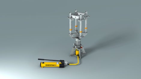 Die Hydraulik-Einheit besteht aus Hubzylinder und Handpumpe. Am Manometer lassen sich sowohl der Druck [bar] als auch die Kraft [kN] ablesen.<br/>