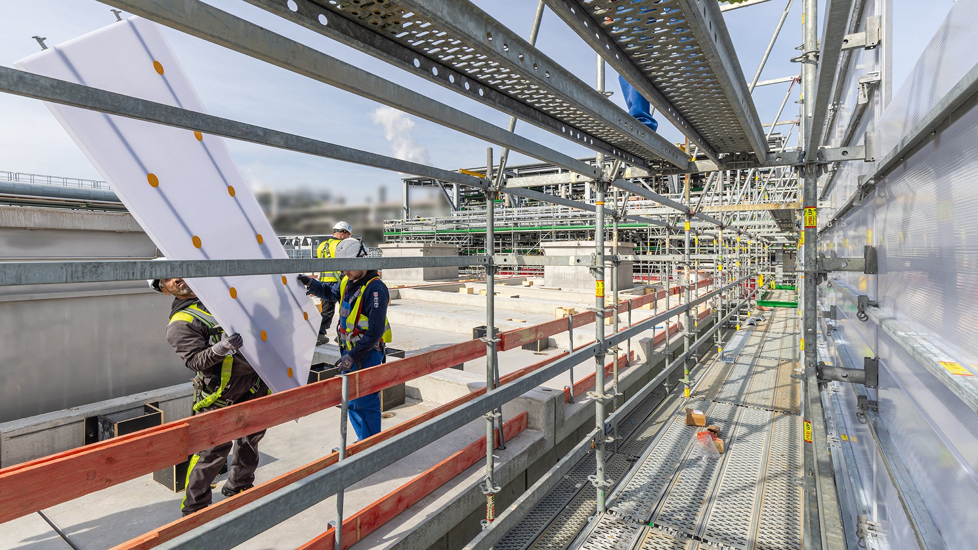 Die blickdichten, aber dennoch lichtdurchlässigen Paneele des PERI UP Cladding sind leicht und lassen sich aus gesicherter Position einfach und effizient montieren