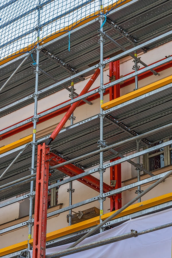 An der bis zu 15 m hohen Hauptfassade übernehmen die roten VARIOKIT Bauteile die Fassadenabstützung und werden durch das PERI UP Fassadengerüst ergänzt. Die Gerüste können sowohl gemeinsam als auch getrennt stehen. So kann das Stützgerüst bereits früher im Bauverlauf entfernt werden, sobald die Abstützung nicht mehr notwendig ist.