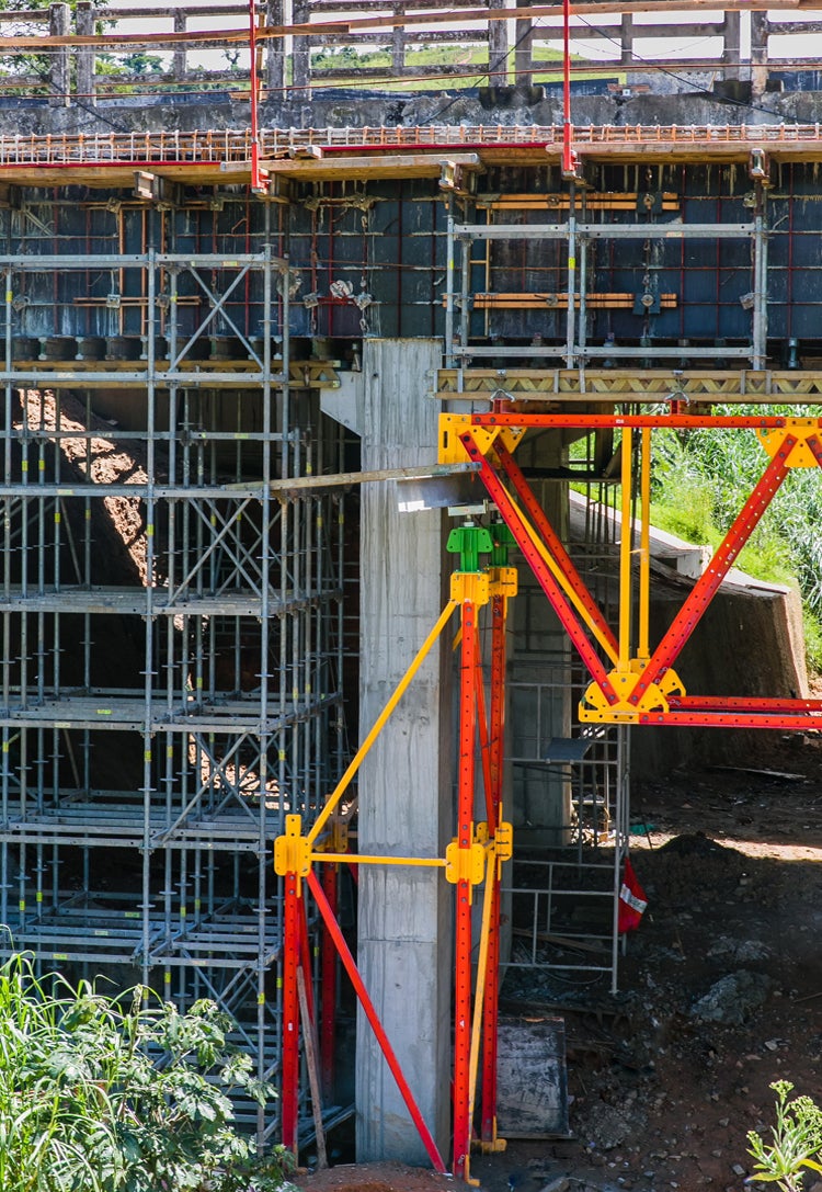 Detalhe da utilização do Sistema ALPHAKIT como torre de apoio da treliça e do cabeçal regulável para desforma do conjunto.