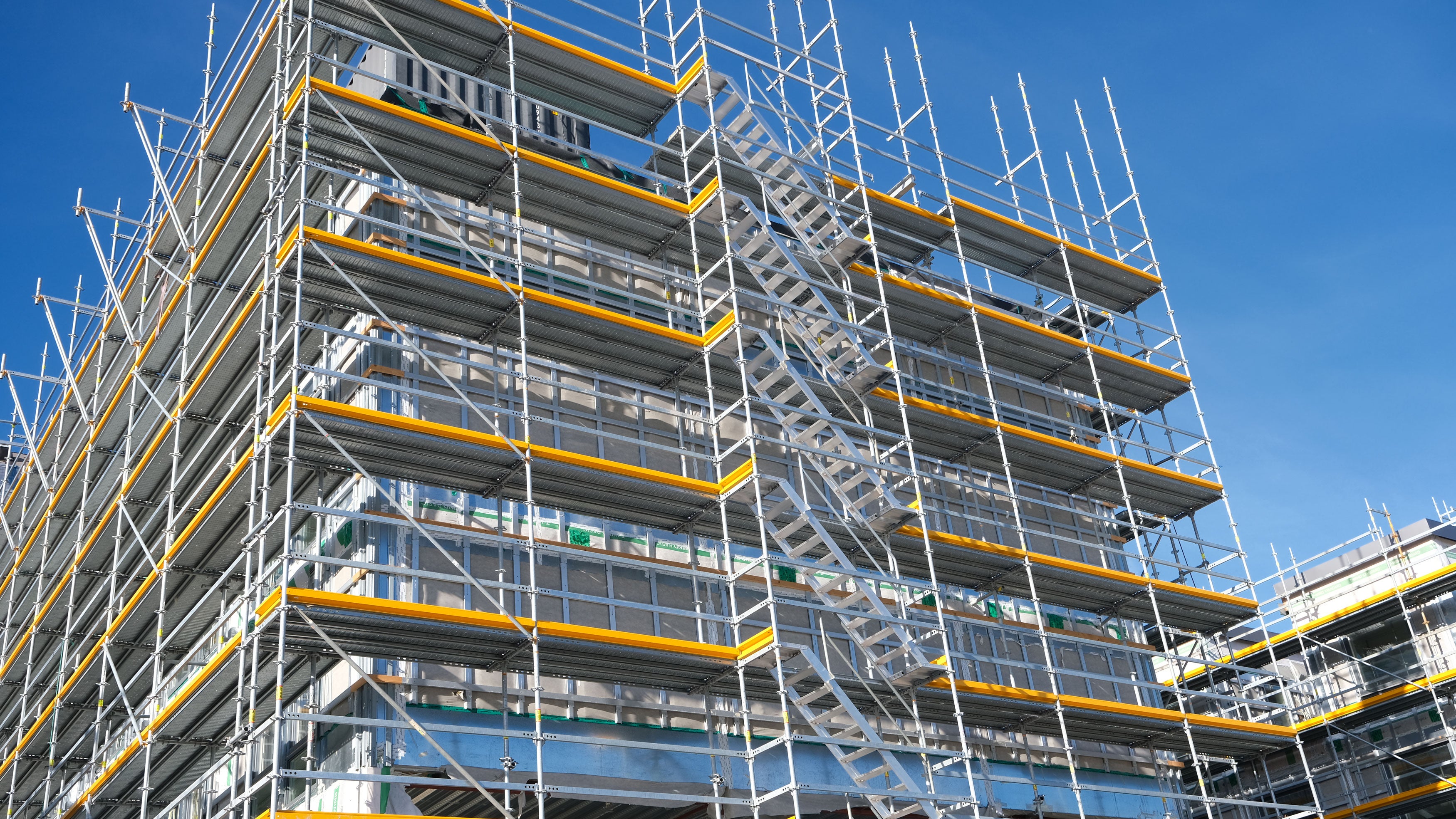 Sikkert og fleksibelt facadestillads fra PERI UP monteret på facade til renovering og adgangsarbejde.