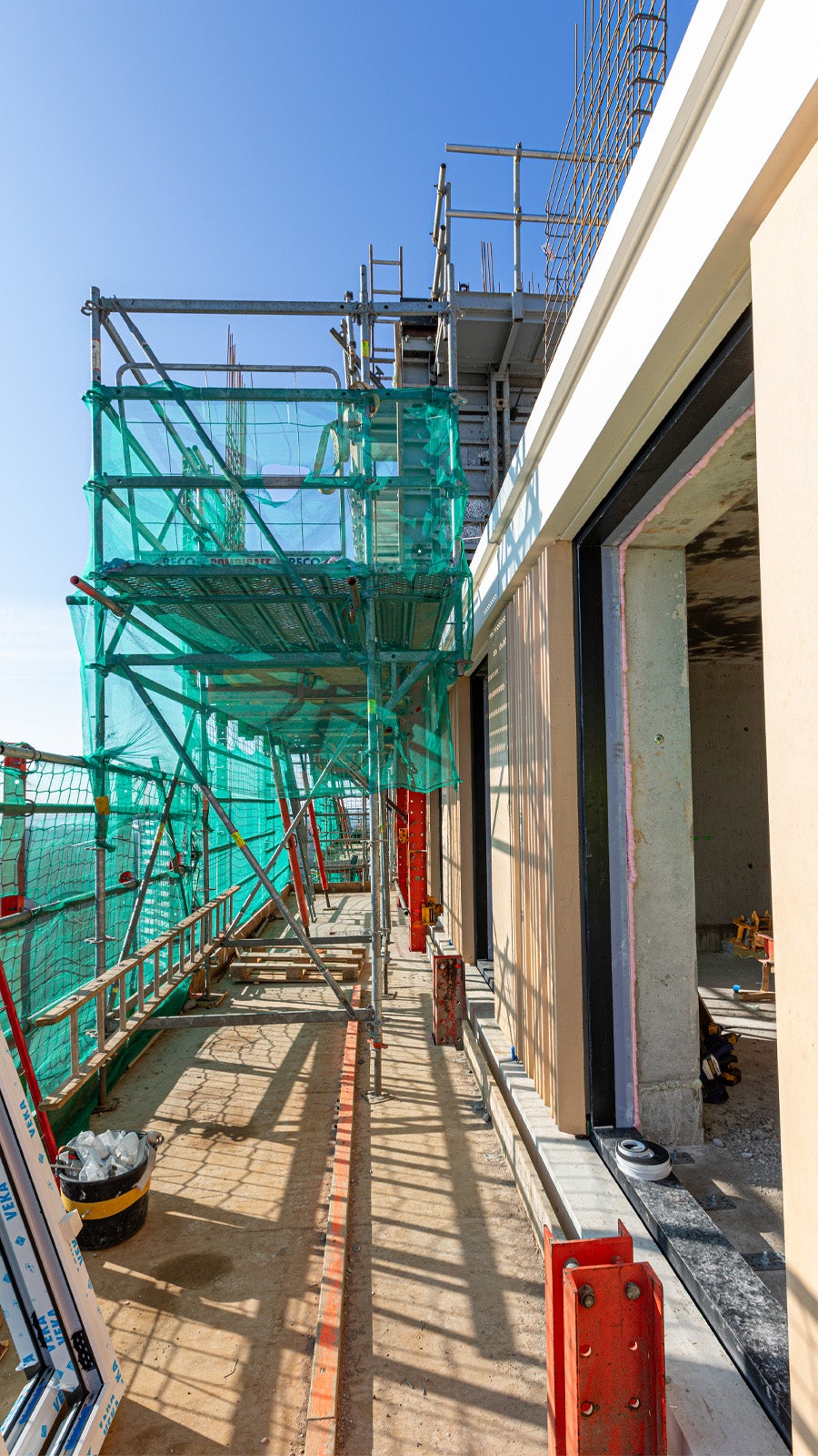 Dankzij de PERI UP Omloopsteiger kan er vanuit de klimsteiger een verdieping hoger naar de naastgelegen steiger op de bovenste vloer gelopen worden.