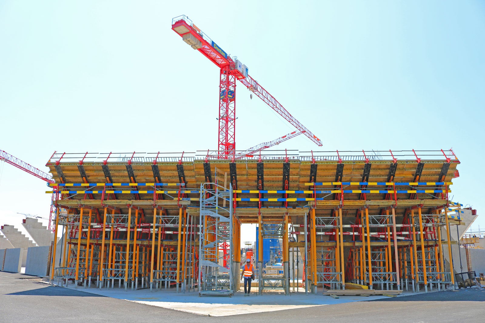 Deux ailes convergent au-dessus de l'entrée pour former un voile continu.