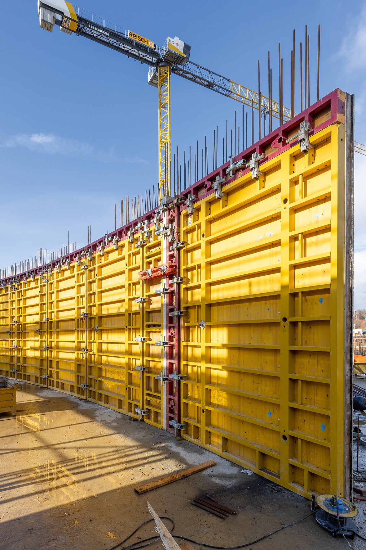 Das im Eigenbestand befindliche und in Reisch-Kundenfarbe beschichtete Schalungsmaterial wurde projektspezifisch mit Systemgerät aus dem umfangreichen PERI Mietpark ergänzt. Mittels aufgedoppelter Knaggenkästen auf den MAXIMO Struktur Wandschalungselementen ließen sich runde Wände maßgenau, in sehenswerter Sichtbetonqualität und dank der einseitig bedienbaren MX Ankertechnik in kurzer Zeit herstellen.