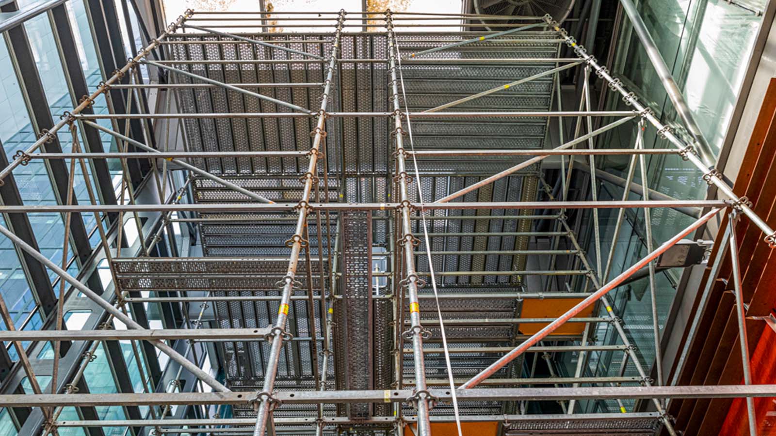 Bij de entree staat een PERI UP werksteiger met intern verwerkte ladderopgangen. Hiermee kan er op een groot oppervlak op hoogte veilig gewerkt worden.