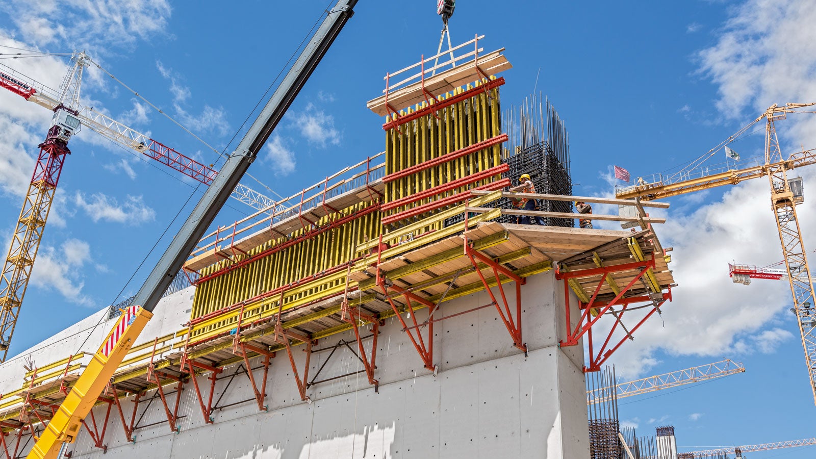 Em alturas maiores, os suportes de subida CB servem como sistemas de plataformas para a forma de paredes. Para cumprir os requisitos de concreto arquitetônico, uma solução de ancoragem especial foi usada.