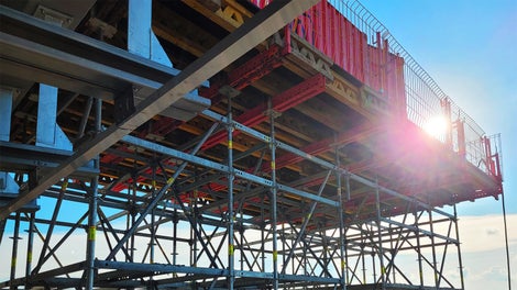 Platforma VARIOKIT na rusztowaniu podporowym PERI UP FLEX na kontener do prefabrykacji blachy zapewniająca bezpieczeństwo na wysokości 14 m.