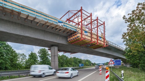 Um die Gesimskappenschalung ohne Sperrung und ohne Gefährdung der Kreuzungsbereiche montieren und demontieren zu können, diente ein 12 m langer Montagewagen aus VARIOKIT Bauteilen als Arbeitsbühne.