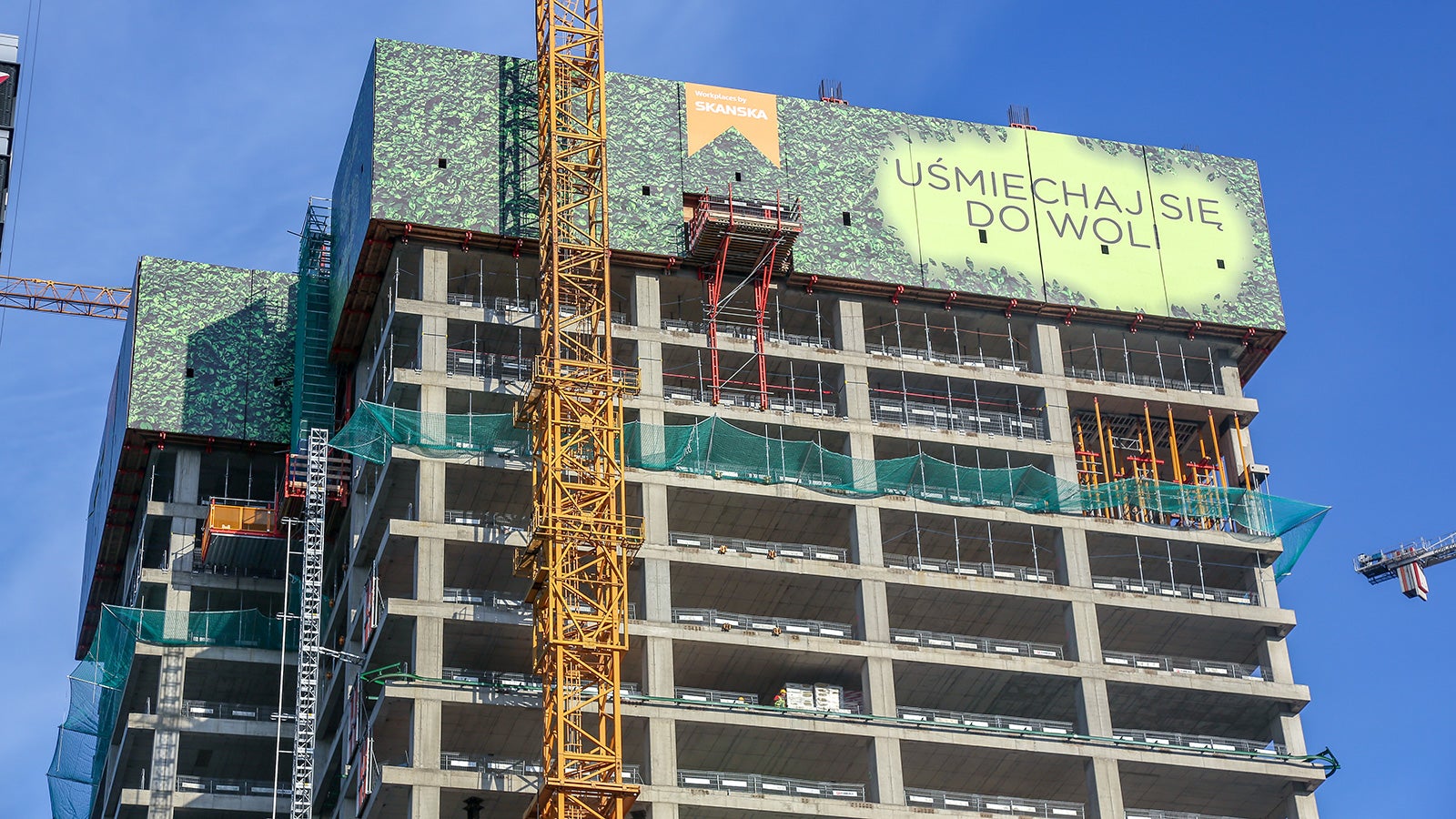 Obwód budynku został zabezpieczony szczelnymi osłonami przeciwwiatrowymi RCS, które umożliwiają bezpieczne i efektywne prowadzenie robót na dużej wysokości.