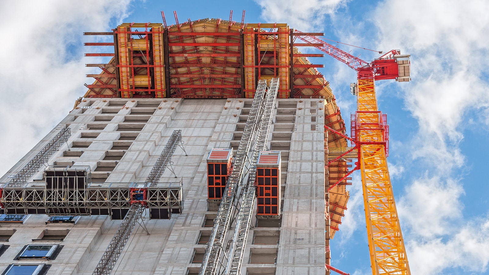 For constructing the barrel-shaped section of the Henninger Turm, a cantilevered working and scaffolding platform up to 8 m long was formed at a height of 100 m on the basis of rentable standard system components in 100 m height.