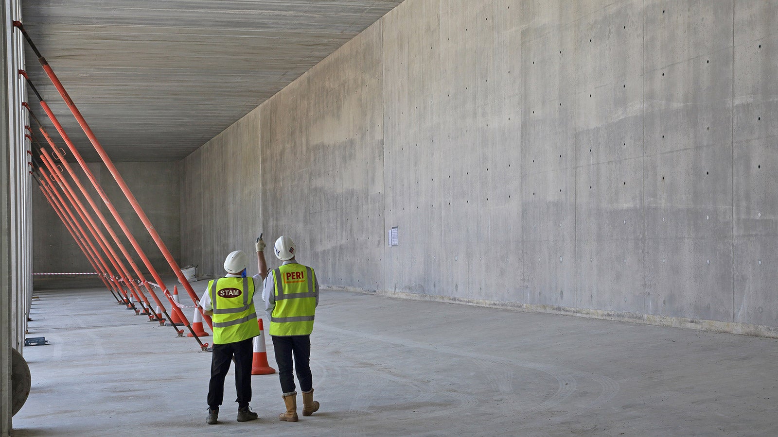 Internal view of resevoir walls. Neat high concrete finish of walls. Personnel show shear height of resevoir walls